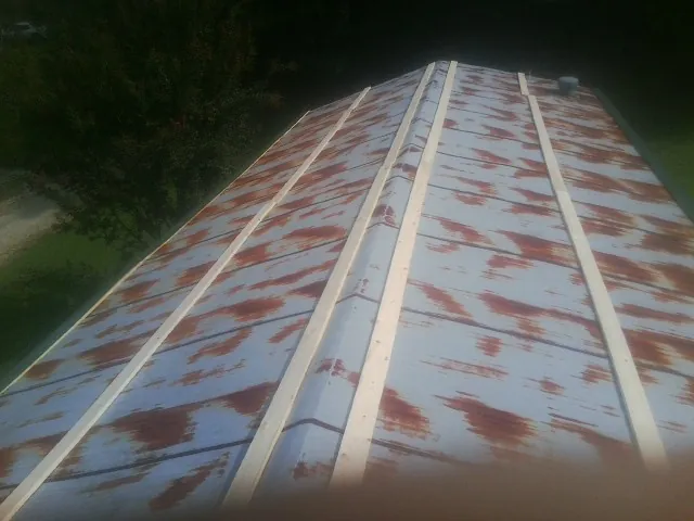 Rusted metal roof panels with new wood purlins before replacement — Storm Damage Roof Repair in Hickory Flat by Roofing Brothers