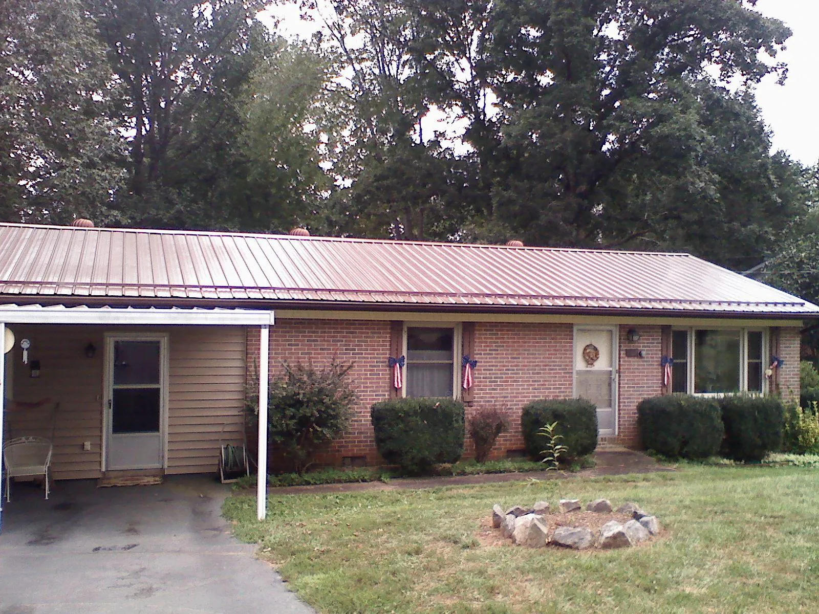 Bronze metal roof and carport on a brick ranch home — Roof Repair work by our crew in Hickory Flat