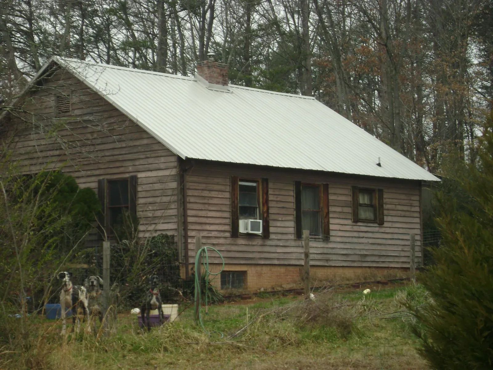 White metal roof on an old wood sided farmhouse, from a Metal Roof Installation job in Hickory Flat